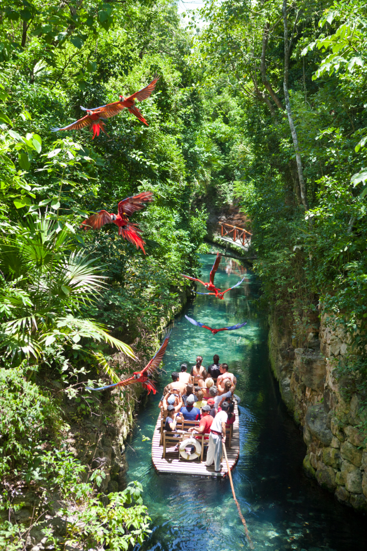 Río subterráneo con visitantes nadando en el parque Xcaret